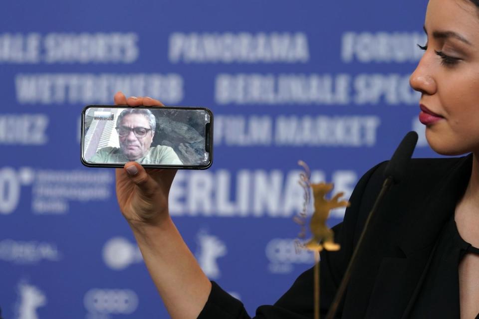 Baran Rasoulof phones Iranian director Mohammad Rasoulof, winner of the Golden Bear for Best Film for the film “There Is No Evil” at the award winners press conference during the 70th Berlinale International Film Festival Berlin (Getty Images)