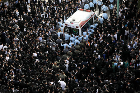 Ultra-Orthodox Jews gather as Israeli police officers surround an ambulance carrying the body of prominent spiritual leader Rabbi Aharon Yehuda Leib Steinman, who died on Tuesday at the age of 104, during his funeral ceremony in Bnei Brak near Tel Aviv, Israel December 12, 2017. REUTERS/Amir Cohen