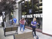 This photo taken Thursday, Aug. 22, 2019 in downtown Reno, Nev., shows University of Nevada, Reno students walking past a Circus Circus casino-hotel tower that has been renamed Wolf Pack Tower. It will house about 1,300 UNR students for the coming school year after a July gas explosion shut down the two largest dorms on the main campus a half-mile away. (AP Photo/Scott Sonner)