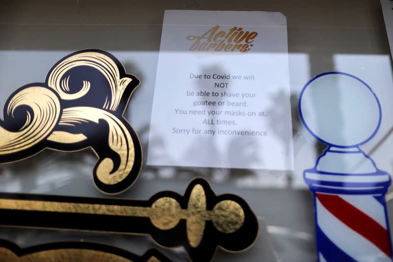 A notice is seen in the window of Active Barbers, amid the global outbreak of the coronavirus disease (COVID-19), in Santa Monica