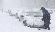 A man clears snow from his car during a snowstorm in Quebec City, December 15, 2013. Between 15 and 30cm of snow are expected to fall on the different regions of eastern Canada today, according to Environment Canada. REUTERS/Mathieu Belanger (CANADA - Tags: ENVIRONMENT SOCIETY)