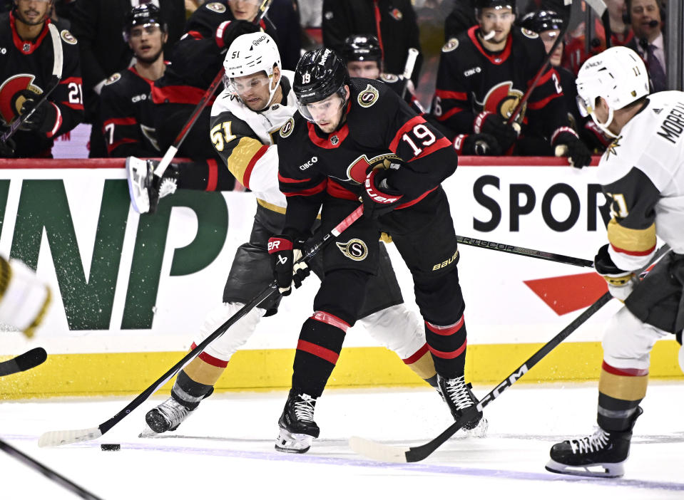 Ottawa Senators right wing Drake Batherson (19) works to keep the puck inside the blue line in front of Vegas Golden Knights center Byron Froese (51) during the second period of an NHL hockey game Saturday, Feb. 24, 2024, in Ottawa, Ontario. (Justin Tang/The Canadian Press via AP)