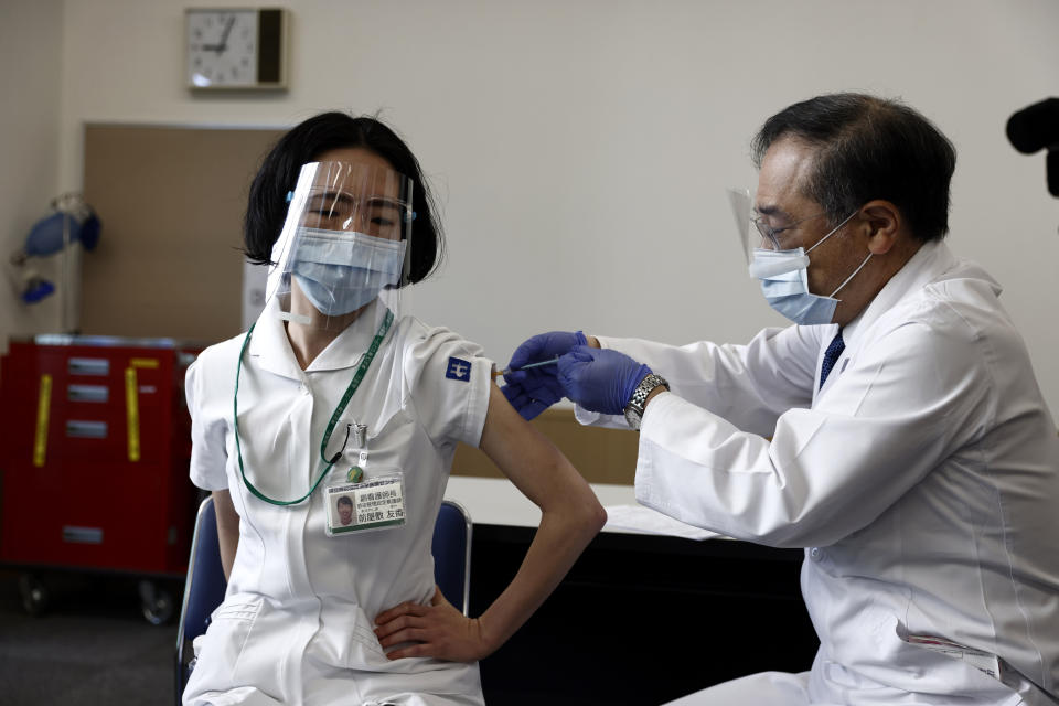 A medical worker receives a dose of COVID-19 vaccine at Tokyo Medical Center in Tokyo Wednesday, Feb. 17, 2021. Japan's first coronavirus shots were given to health workers Wednesday, beginning a vaccination campaign considered crucial to holding the already delayed Tokyo Olympics. (Behrouz Mehri/Pool Photo via AP)