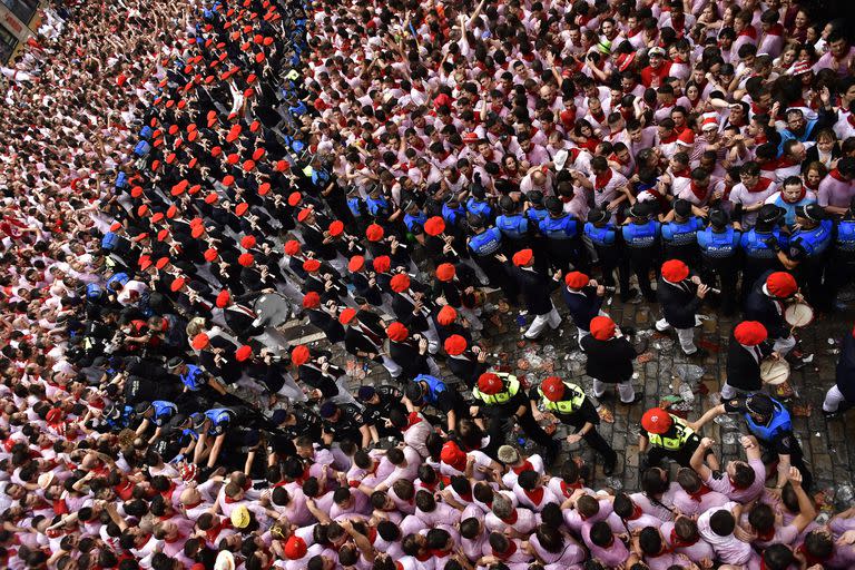 Una banda toca entre los juerguistas que abarrotan la plaza del ayuntamiento esperando la apertura oficial de las fiestas de San Fermín 2022