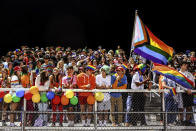 In this photo provided by Fritz Senftleber, people participate in the “drag ball" halftime show at Burlington High School on Friday, Oct. 15, 2021 in Burlington, Vt. The event was part of that school's homecoming and was sponsored by the Gender Sexuality Alliance from Burlington and South Burlington high schools. The football game was between a team made up of students from three Burlington-area schools Burlington, South Burlington and Winooski High Schools who played against St. Johnsbury Academy. (Fritz Senftleber via AP)