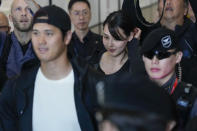 Mamiko Tanaka, center, wife of Los Angeles Dodgers Shohei Ohtani, left, walks with him through a terminal during the baseball team's arrival at Incheon International Airport, Friday, March 15, 2024, in Incheon, South Korea, ahead of the team's baseball series against the San Diego Padres. (AP Photo/Ahn Young-joon)