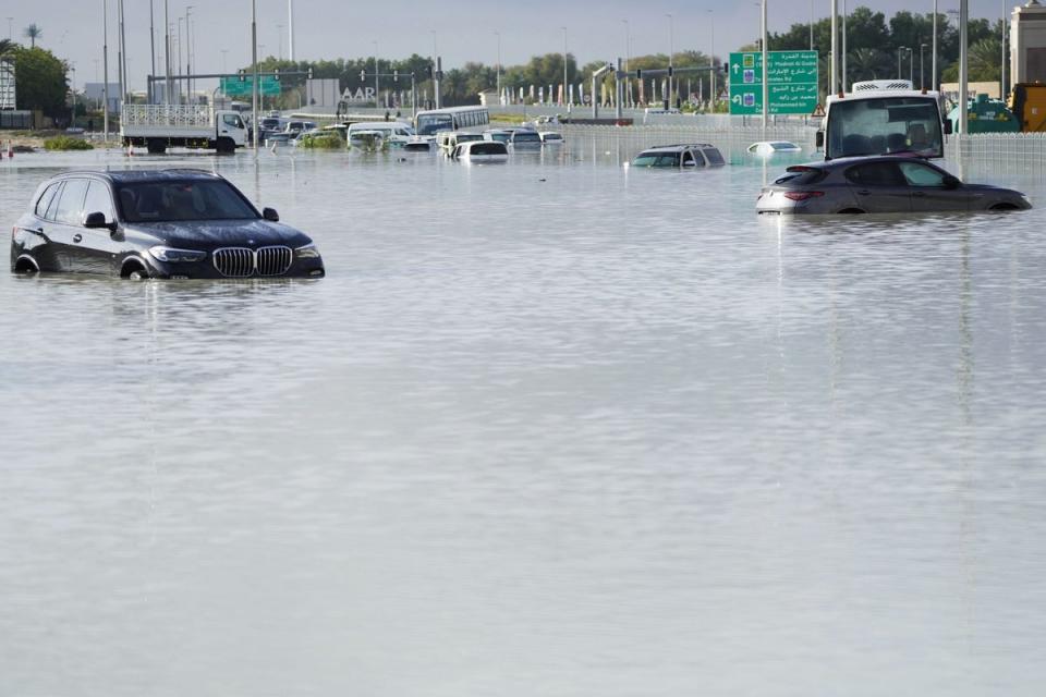 Vehicles sit abandoned in floodwater covering a major road (AP)