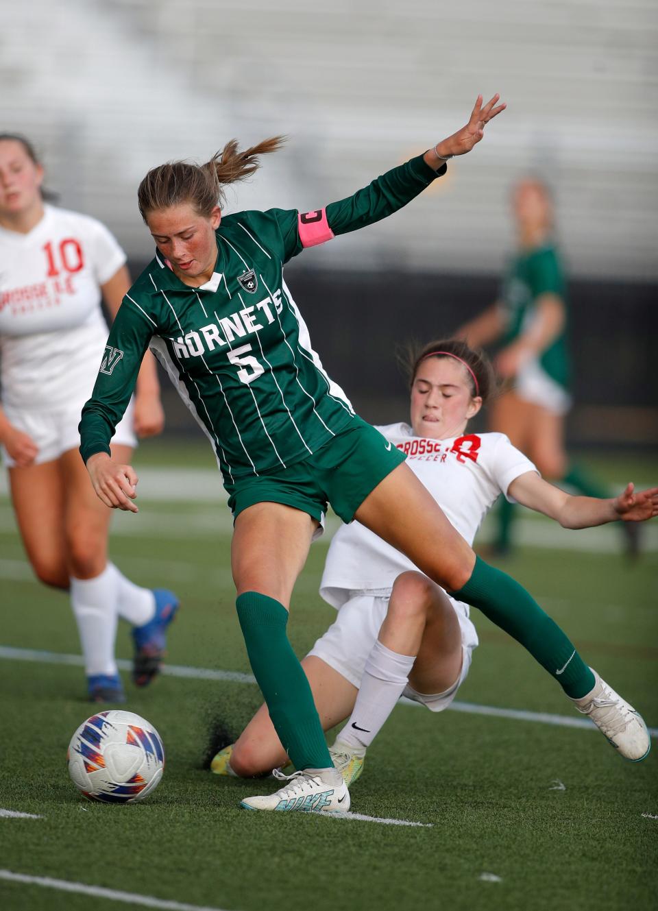 Williamston's Ella Kleiver, left, beats out Grosse Ile's Mallory Botten for the ball, Thursday, June 8, 2023, at Lansing Catholic High School.