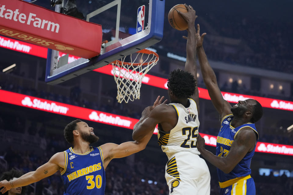 Indiana Pacers forward Jalen Smith (25) dunks against Golden State Warriors guard Stephen Curry (30) and forward Draymond Green during the first half of an NBA basketball game in San Francisco, Monday, Dec. 5, 2022. (AP Photo/Godofredo A. Vásquez)