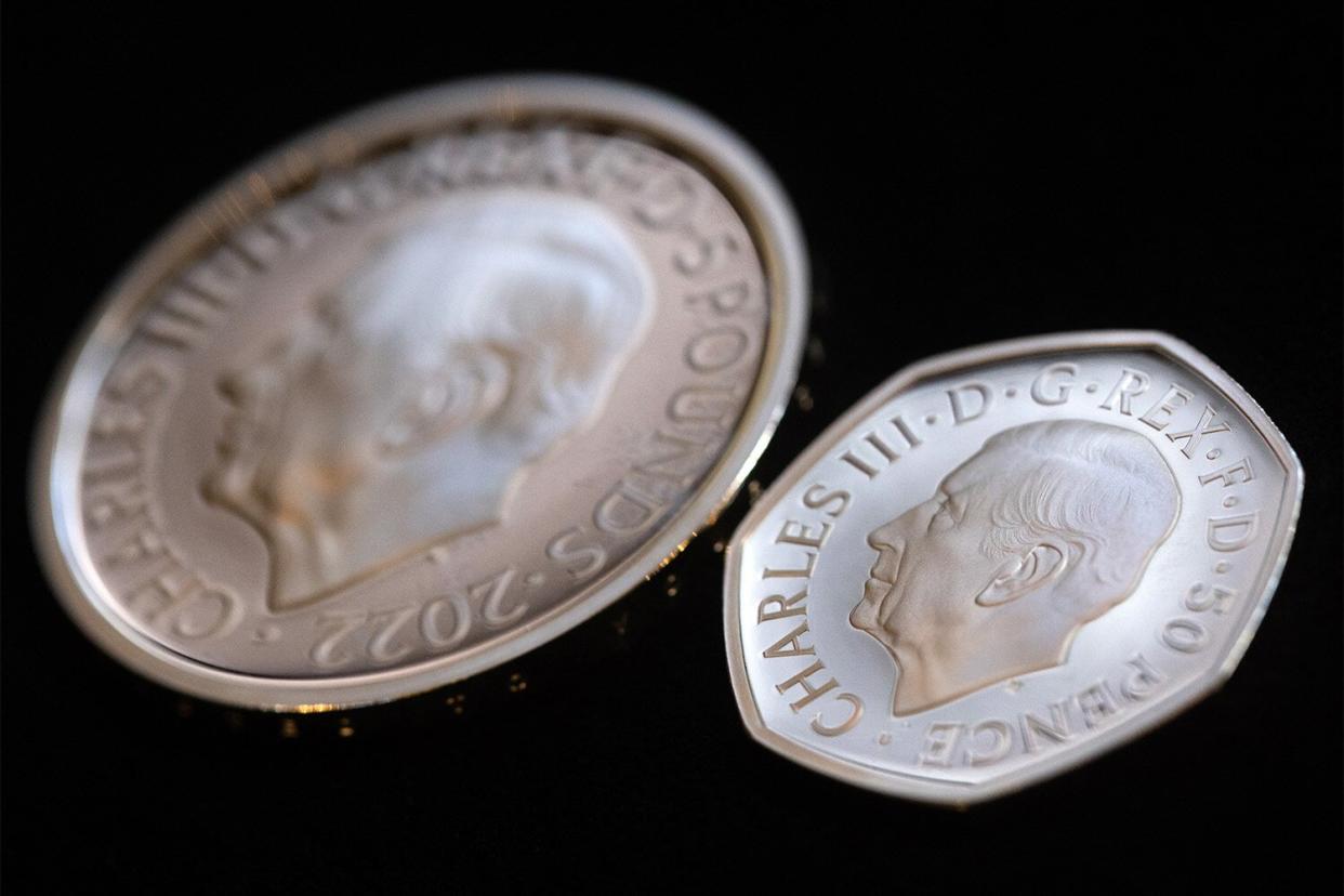 A 50 pence coin featuring the head of King Charles III displayed next to a five pound commemorative crown piece coin by the Royal Mint in London, UK, on Thursday, Sept. 29, 2022. The King's portrait which, sculptor Martin Jennings designed to face the opposite direction to his mothers, was approved by the monarch himself and seen by chancellor Kwasi Kwarteng in a process that kicked off after the Queen passed away. Photographer: Chris Ratcliffe/Bloomberg via Getty Images