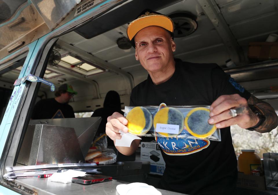 Julio Berrios of Stray Dog was among the vendors across Northeast Ohio who knew people would be craving all things eclipse today. Berrios was selling eclipse cookies at the Akron 24 Eclipse With Us party downtown.