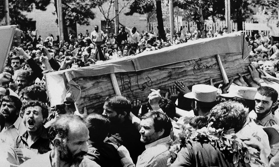 FILE - In this July 7, 1988 file photo, Iranian mourners carry one of 72 caskets to the Cemetery of Martyrs after attending a "Death to America" rally outside the Majlis, or Iranian parliament, in Tehran, Iran. The Western allegation that Iran shot down a Ukrainian jetliner and killed 176 people offers a grim echo for the Islamic Republic, which found itself the victim of an accidental shootdown by American forces over 30 years ago. (AP Photo/Greg English, File)