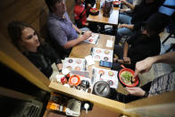 Frank Striegl, bottom right, a guide of Tokyo Ramen Tours, explains participants of a ramen tasting tour at Nagi, which offers "Fukuoka fusion," type ramen at Shibuya district on April 2, 2024, in Tokyo. (AP Photo/Eugene Hoshiko)