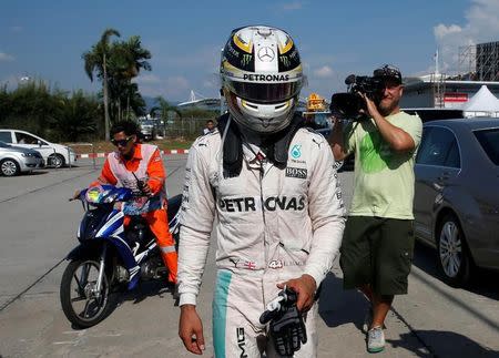 Formula One - F1 - Malaysia Grand Prix - Sepang, Malaysia- 2/10/16 Mercedes' Lewis Hamilton of Britain returns to the paddock after his car caught fire during the race. REUTERS/Edgar Su