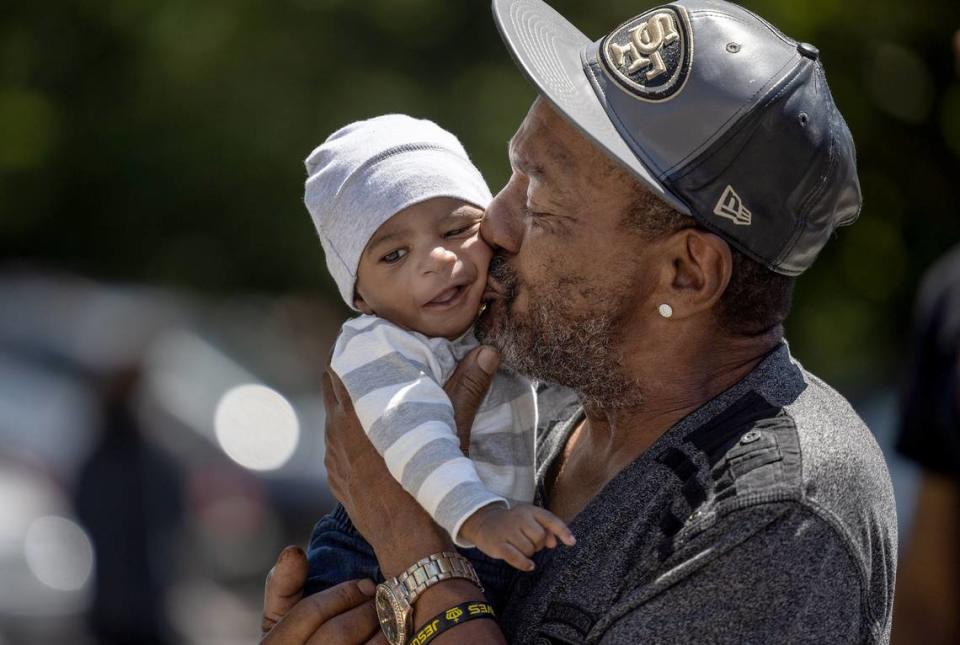 John Clay kisses his grandson, John Clay III, 5 months, as they wait in line for free baby formula at StarMed Healthcare. Some Charlotte families face increased pressure around breastfeeding amid the formula shortage.