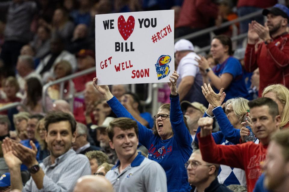 A Kansas fan holds a get-well-soon sign for Jayhawks head coach Bill Self (not pictured) in the first half Thursday of a game against West Virginia at T-Mobile Center in Kansas City.