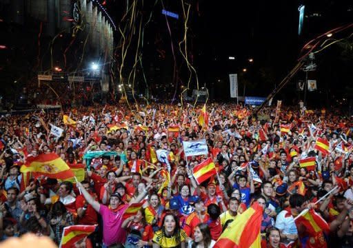 Supporters of the Spanish football team wave national flags in Madrid after their team defeated Italy 4-0 in the Euro 2012 football championships final. A red-and-yellow sea of delirious fans swamped central Madrid in a wild all-night party before hailing the return on Monday of their conquering Euro 2012 heroes