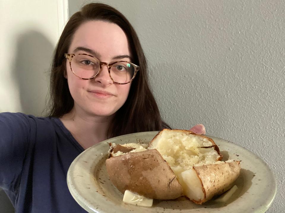 The writer holding the cooked jacket potato on a plate
