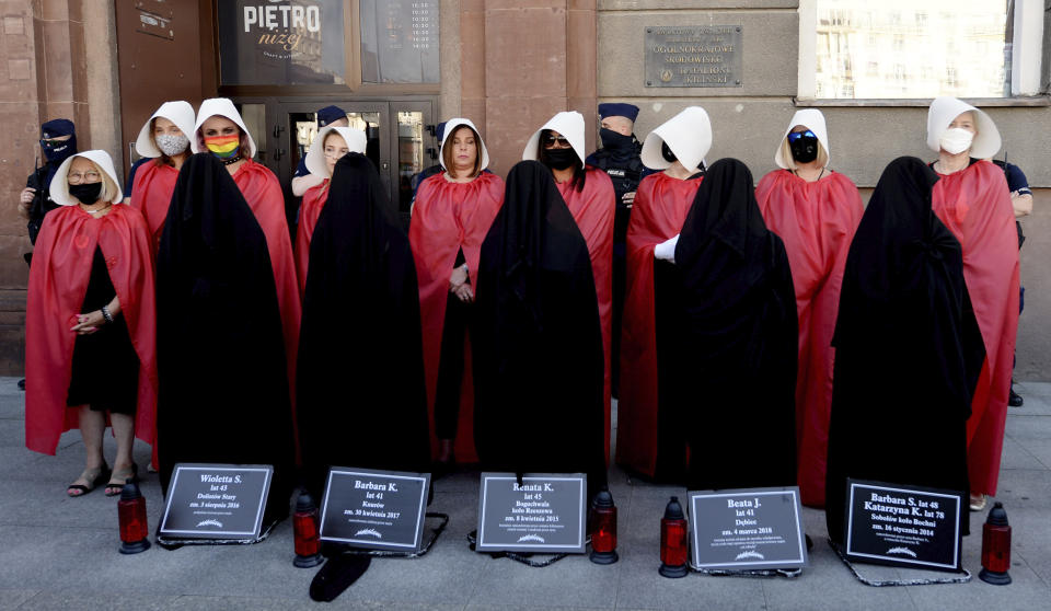 Members of Poland's women's rights organizations, with obituaries of women who fell victim to violence, protest against plans by the right-wing government to withdraw from Europe's Istanbul Convention on prevention of violence against women and children, in Warsaw, Poland, Friday, July 24, 2020. (AP Photo/Czarek Sokolowski)