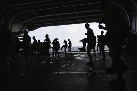 U.S. Navy sailors dance as they exercise on a deck of the U.S. Navy aircraft carrier USS George Washington, during a tour of the ship in the South China Sea November 7, 2013. REUTERS/Tyrone Siu