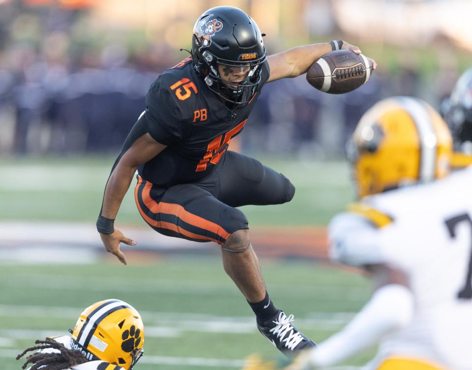 Massillon quarterback DaOne Owens leaps over a defender in the second quarter against Valdosta, Ga., Friday, Aug. 18, 2023.