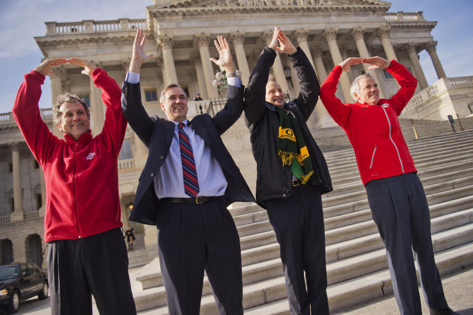 From left, Sens. Sherrod Brown (D-Ohio), Jeff Merkley (D-Ore.), Ron Wyden (D-Ore.) and Rob Portman (R-Ohio) make symbols that spell "Ohio" on Jan. 13, 2015, as the result of a football bet. Ohio State beat the University of Oregon 42-20 in the NCAA national football championship.