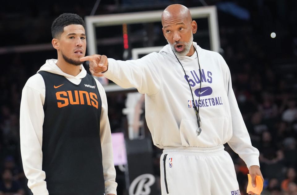 Phoenix Suns head coach Monty Williams talks to his players with guard Devin Booker by his side as the team holds an open practice for fans at the Footprint Center on Saturday, Oct. 1, 2022. 