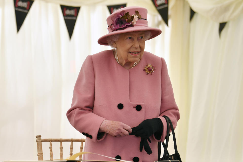 SALISBURY, ENGLAND - OCTOBER 15: Britain's Queen Elizabeth II stands after signing a visitor's book during her visit to the Defence Science and Technology Laboratory (Dstl) at Porton Down science park on October 15, 2020 near Salisbury, England. The Queen and the Duke of Cambridge visited the Defence Science and Technology Laboratory (Dstl) where they were to view displays of weaponry and tactics used in counter intelligence, a demonstration of a Forensic Explosives Investigation and meet staff who were involved in the Salisbury Novichok incident. Her Majesty and His Royal Highness also formally opened the new Energetics Analysis Centre. (Photo by Ben Stansall - WPA Pool/Getty Images)