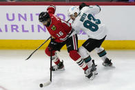 Chicago Blackhawks left wing Jujhar Khaira, left, controls the puck against San Jose Sharks left wing Matt Nieto during the first period of an NHL hockey game in Chicago, Sunday, Nov. 28, 2021. (AP Photo/Nam Y. Huh)