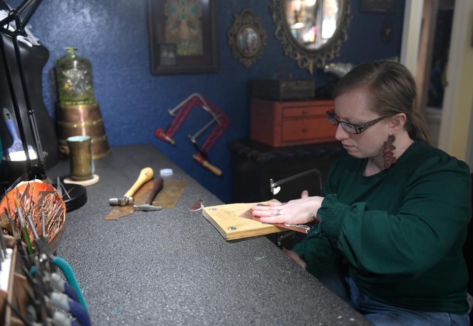 Dawna Gillespie saws copper for her jewelry in her home studio, Wednesday, April 24, 2024, in Ransom Canyon.