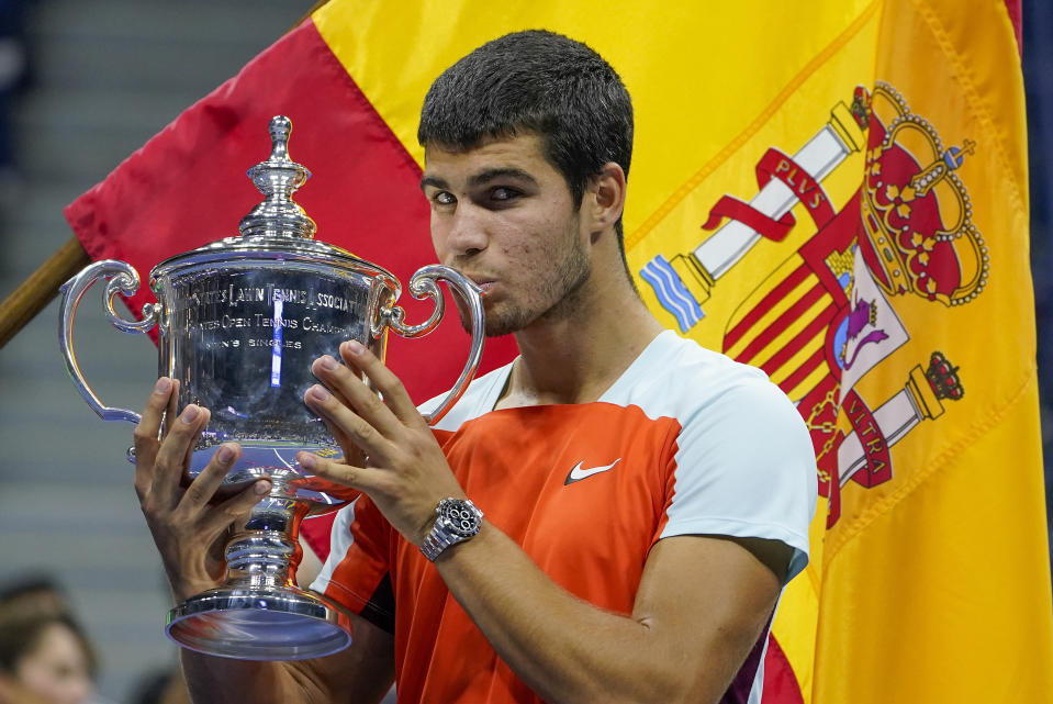 Carlos Alcaraz besa el trofeo de campeón del US Open tras vencer a Casper Ruud en la final, el domingo 11 de septiembre de 2022. (AP Foto/John Minchillo)