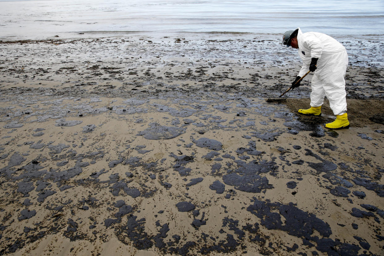 A worker removes oil from the sand at Refugio State Beach in the Santa Barbara Channel, north of Goleta, Calif., as cleanup continued a month after the May 19 oil spill north of Santa Barbara, Calif. (Photo: Jae C. Hong/AP)