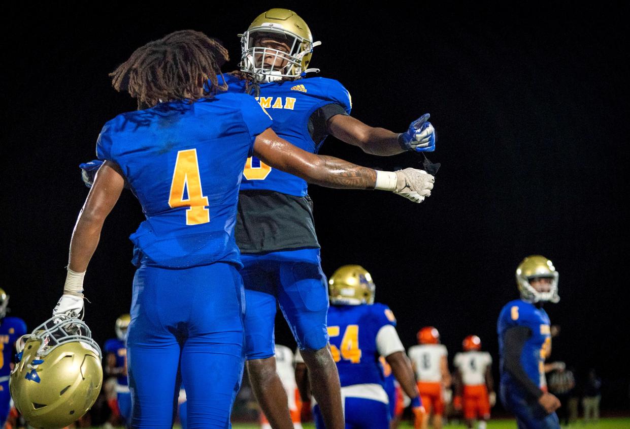 Cardinal Newman Dallas Desouza celebrates with Jaylin Brown, (4) against Benjamin in the regional semifinal playoff football game in West Palm Beach on November 17, 2023.