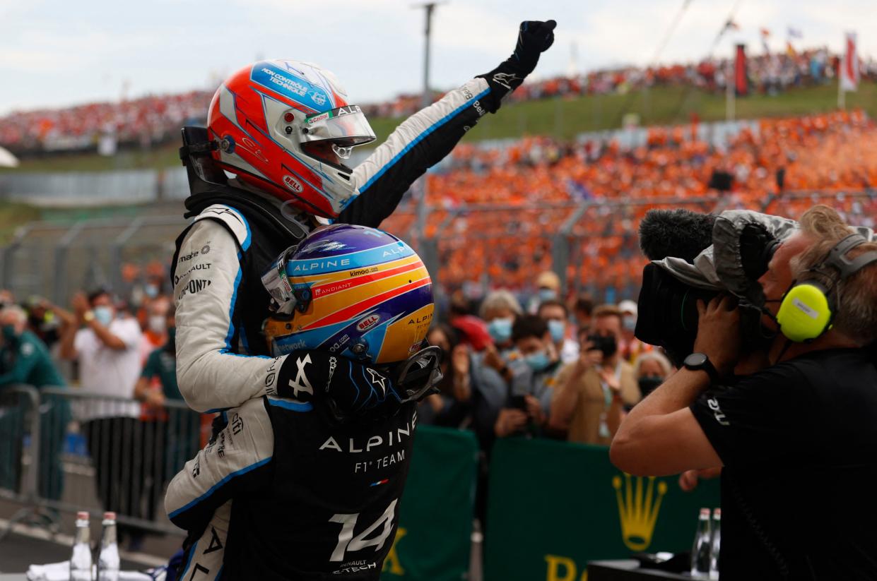 Alpine's French driver Esteban Ocon is carried by Alpine's Spanish driver Fernando Alonso after the Formula One Hungarian Grand Prix at the Hungaroring race track in Mogyorod near Budapest on August 1, 2021. (Photo by FLORION GOGA / AFP) (Photo by FLORION GOGA/AFP via Getty Images)