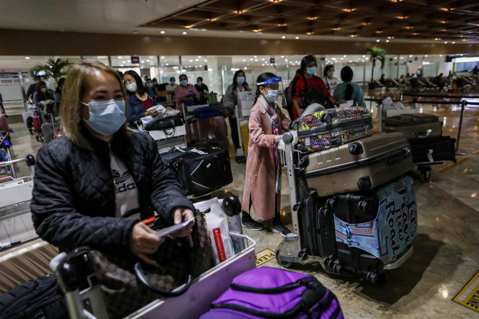 Passengers wearing protective masks to prevent the spread of COVID-19 push their carts as they arrive at Manila's International Airport. Manila, Philippines. (Photo by: Basilio H. Sepe/ Majority World/Universal Images Group via Getty Images)