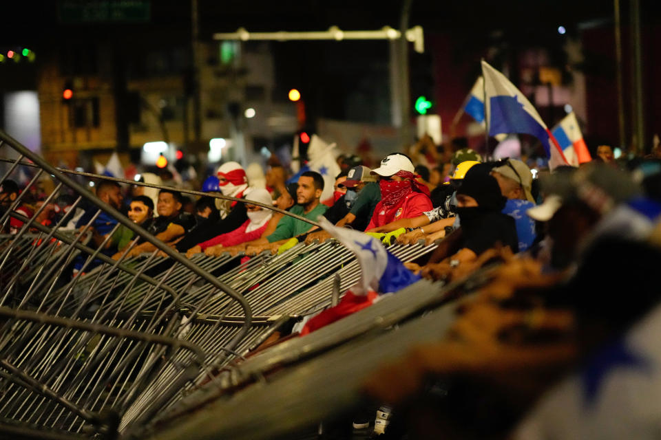 Demonstrators tear down a police barricade during a protest against a recently approved mining contract between the government and Canadian mining company First Quantum, in Panama City, Tuesday, Oct. 31, 2023. (AP Photo/Arnulfo Franco)