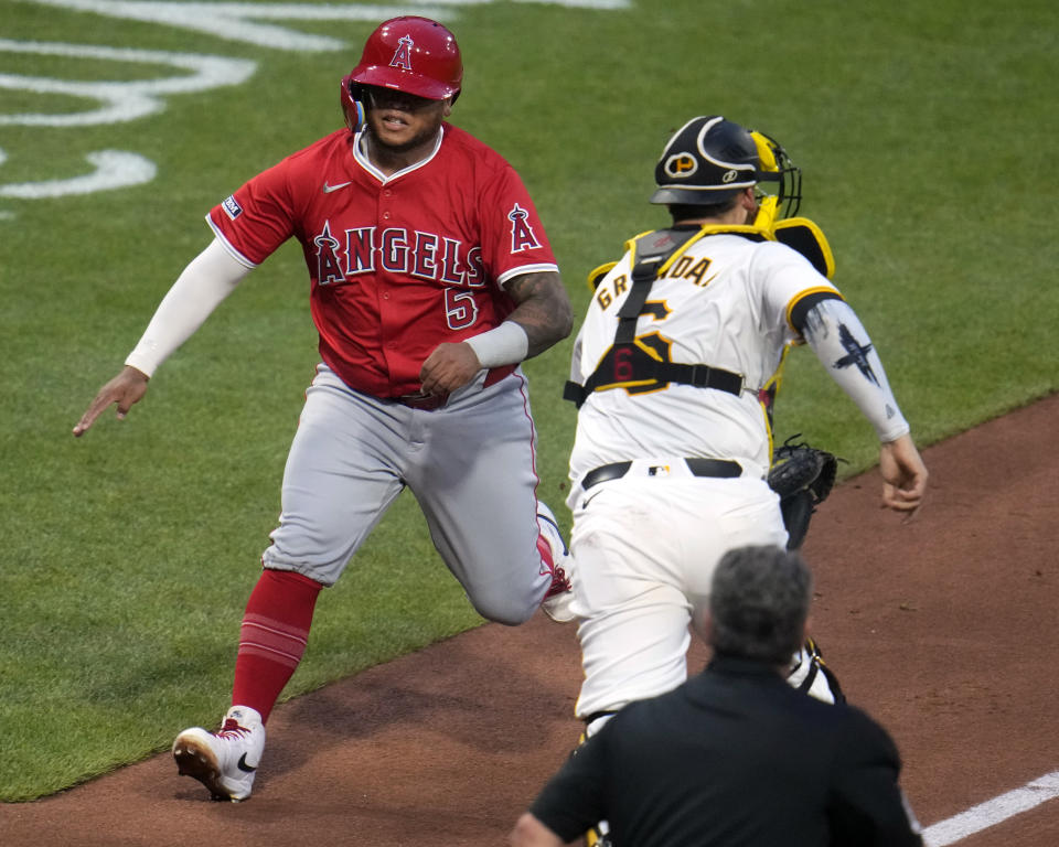 Los Angeles Angels' Willie Calhoun (5) scores past Pittsburgh Pirates catcher Yasmani Grandal on a single by Logan O'Hoppe off Pirates starting pitcher Quinn Priester during the fifth inning of a baseball game in Pittsburgh, Tuesday, May 7, 2024. (AP Photo/Gene J. Puskar)