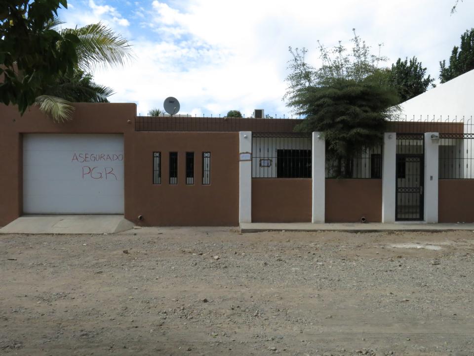 One of the properties that was interconnected by tunnels in the city's drainage system that infamous drug boss Joaquin Guzman Loera, "El Chapo" used to evade authorities is shown, in Culiacan, Mexico, Sunday Feb. 23, 2014. The grafiti on the garage door reads in Spanish "Secured by the PGR". A day after troops narrowly missed infamous Guzman in Culiacan, one of his top aides was arrested. Officials said he told investigators that he picked up Guzman from a drainage pipe and helped him flee to Mazatlan but a wiretap being monitored by ICE agents in southern Arizona provided the final clue that led to the arrest of one of the world's most wanted man. (AP Photo/Adriana Gomez)