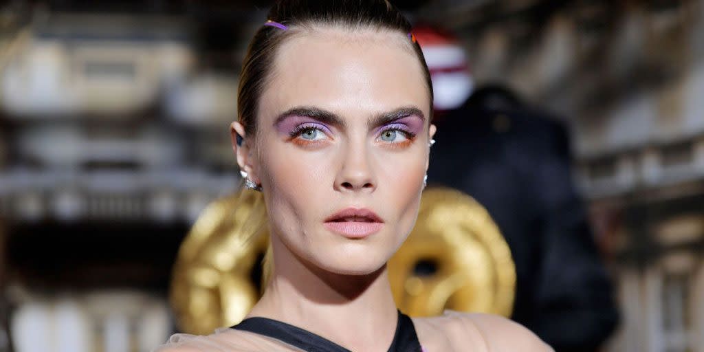 cara delevigne with brightly coloured makeup and her hair up