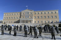 Riot police officers stand guard outside the parliament during a rally in Athens, Greece, on Monday Dec. 6, 2021. Hundreds of protesters marched the streets of the Greek capital, on the 13th anniversary of the 15-year old Alexis Grigoropoulos' fatal shooting by the police. (AP Photo/Michael Varaklas)