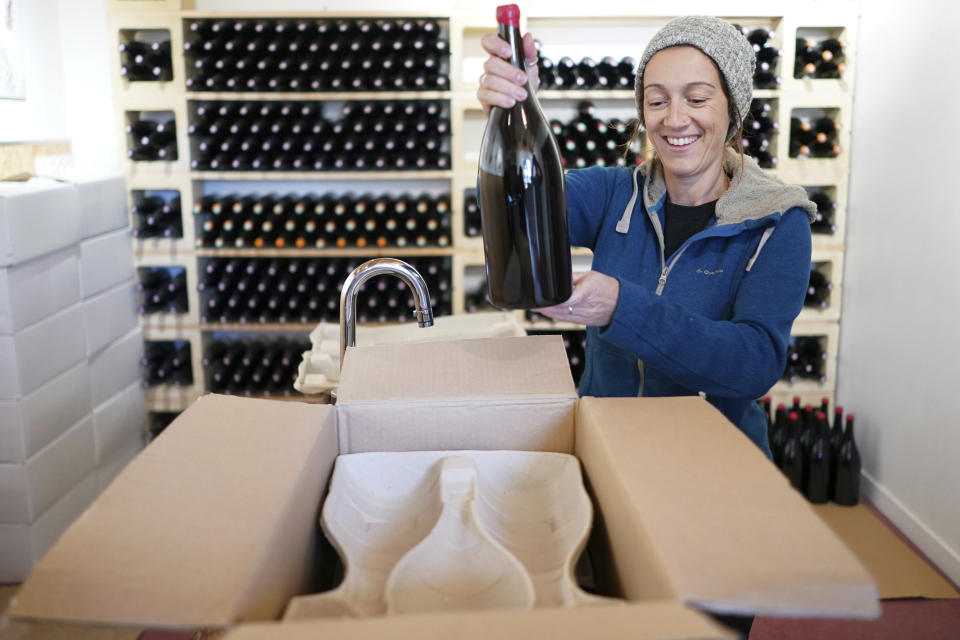 In this Wednesday, Nov. 13, 2019 photo, winemaker Claire Chasselay puts bottles of wine in boxes in her cellar in Chatillon d'Azergues, in the Beaujolais region, eastern France. Celebration is the mot du jour in France’s Beaujolais region on the third Thursday of November, when winemakers and sellers uncork the season’s Beaujolais Nouveau with feasting and fanfare. (AP Photo/Laurent Cipriani)