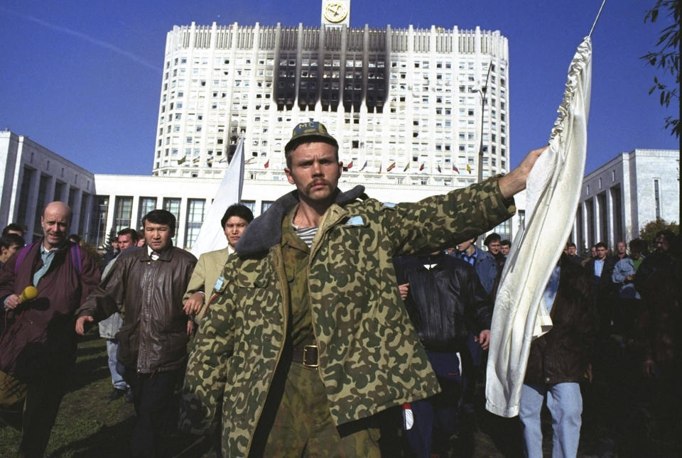FILE - A hard-line defender of the Russian White House holds up a white flag as he leaves the parliament building to surrender in Moscow on Oct. 4, 1993. The October 1993 violent showdown between the Kremlin and supporters of the rebellious parliament marked a watershed in Russia's post-Soviet history. (AP Photo/Alexander Shogin, File)