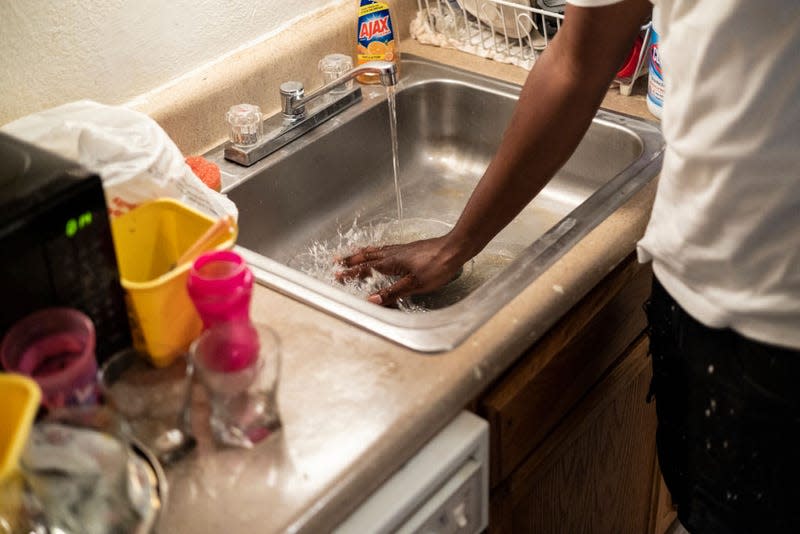 JACKSON, MS - SEPTEMBER 01: Terrence Carter mixes bleach and soap into the water before washing dishes in response to the water crisis on September 01, 2022, in Jackson, Mississippi. The water pressure increased in Carters’ apartment on Wednesday; however, the water is still unsafe to drink. Jackson has been experiencing days without reliable water service after river flooding caused the main treatment facility to fail.