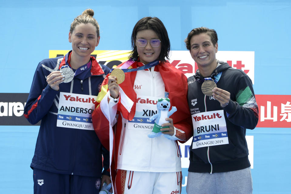 From left, silver medalist Haley Anderson of the United States, gold medalist Xin Xin of China, and bronze medalist Rachele Bruni of Italy stand on the podium after the women's 10km open water swim at the World Swimming Championships in Yeosu, South Korea, Sunday, July 14, 2019. (AP Photo/Mark Schiefelbein)