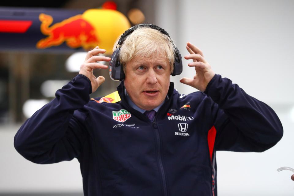 Britain's Prime Minister Boris Johnson dons protective safety wear as he prepares to change a wheel of a Formula One (F1) race car during a Conservative Party general election campaign visit to Red Bull Racing in Milton Keynes, north of London on December 4, 2019. - Britain will go to the polls on December 12, 2019 to vote in a pre-Christmas general election. (Photo by HANNAH MCKAY / POOL / AFP) (Photo by HANNAH MCKAY/POOL/AFP via Getty Images)