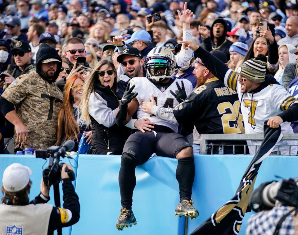 New Orleans Saints running back Mark Ingram (14) jumps into the stands to celebrate with fans after he scored a touchdown during the third quarter at Nissan Stadium Sunday, Nov. 14, 2021 in Nashville, Tenn. But Saints kicker Brian Johnson missed his second extra point of the day after the score, contributing to the 23-21 Titans victory.