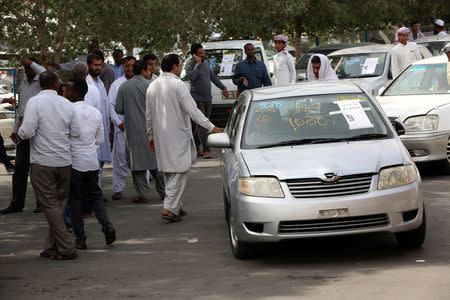 People check used cars displayed for auction at Al Aweer Market in Dubai, UAE April 8, 2018. Picture taken April 8, 2018. REUTERS/Satish Kumar