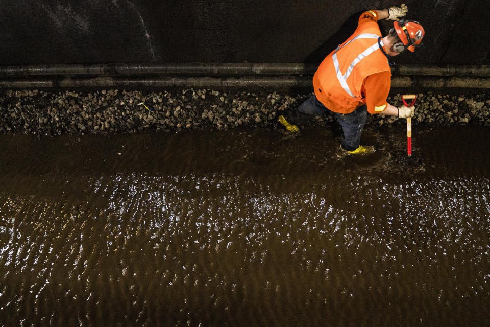 Amtrak workers perform tunnel repairs to a partially flooded train track bed, Saturday, March 20, 2021, in Weehawken, N.J. With a new rail tunnel into New York years away at best, Amtrak is embarking on an aggressive and expensive program to fix a 110-year-old tunnel in the interim. (AP Photo/John Minchillo)