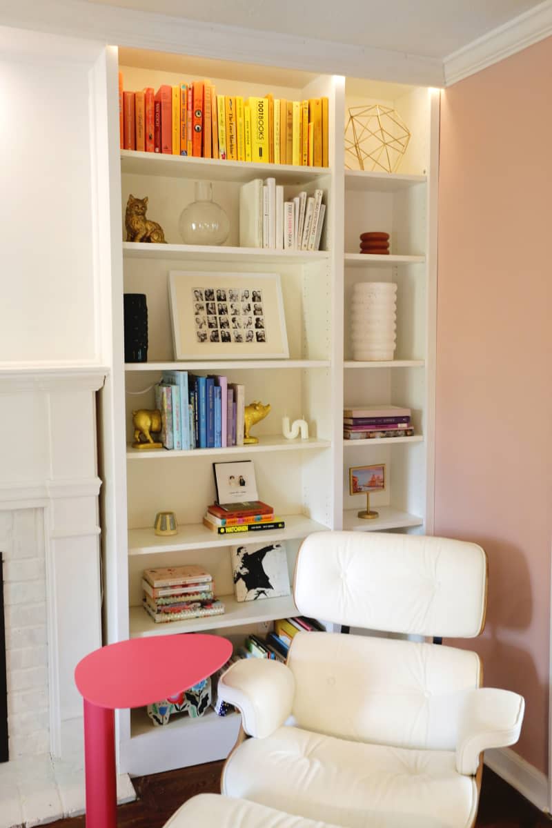 White Eames chair chair in front of bookshelf.