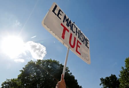 A person holds a banner as families of victims and activists attend a rally against "femicide", gender-based violence targeted at women, in Paris